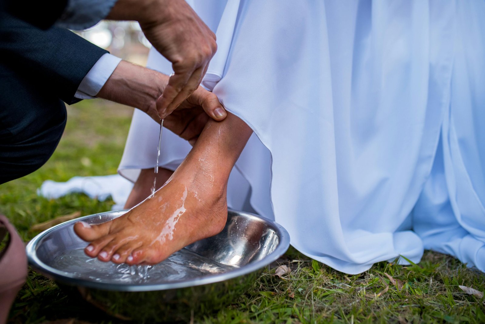 Close-up of a sacred foot washing ritual symbolizing humility at a wedding ceremony.